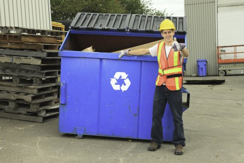Operative performing a site risk assessment near bins